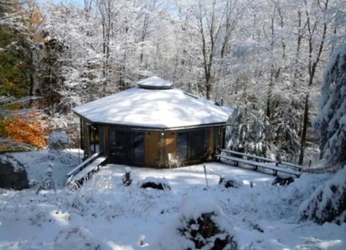 a cabin in the woods in the snow at Imaginative Octogonal Glass Treehouse on Seven Private Acres near Great Barrington, MA in Otis