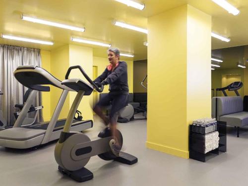 a man standing on a treadmill in a gym at Mercure Rouen Centre Cathédrale in Rouen