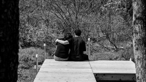 a man and a woman sitting on a wooden bench at Luxurious Safari Tent in Cooperstown, NY - Perfect Glamping Spot for a Romantic Getaway in Cooperstown