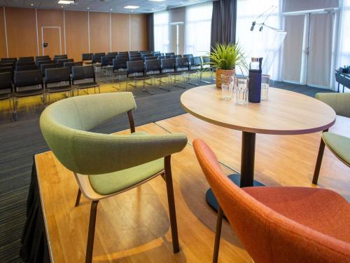 a meeting room with tables and chairs in a building at Novotel Bourges in Bourges