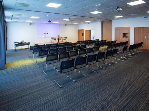 a conference room with chairs and a podium in the background at Novotel Bourges in Bourges