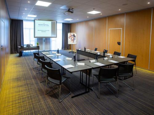 a large conference room with a long table and chairs at Novotel Bourges in Bourges