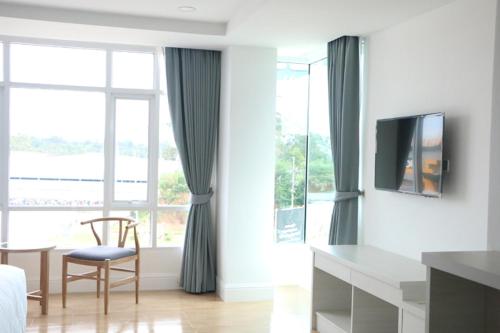 a living room with a chair and a large window at Avada Hotel in Trat