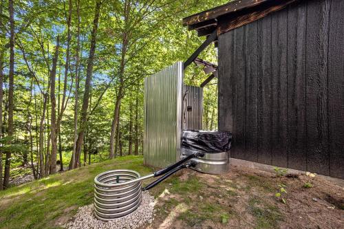 a stack of plates sitting next to a building at Secluded Modern Tiny House with Wood-Fired Hot Tub Near Trails in Sears, Michigan in Sears