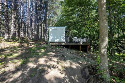 a wooden bench in the middle of a forest at Secluded Modern Tiny House with Wood-Fired Hot Tub Near Trails in Sears, Michigan in Sears