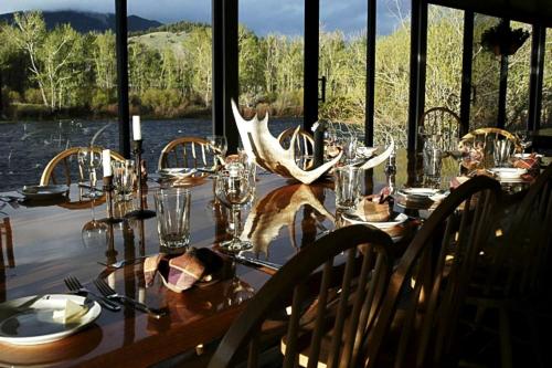 une table avec des bois et des verres dessus avec vue sur l'eau dans l'établissement Fishing Getaway at a Riverside Resort near Beaverhead-Deerlodge National Forest, Montana, à Wise River