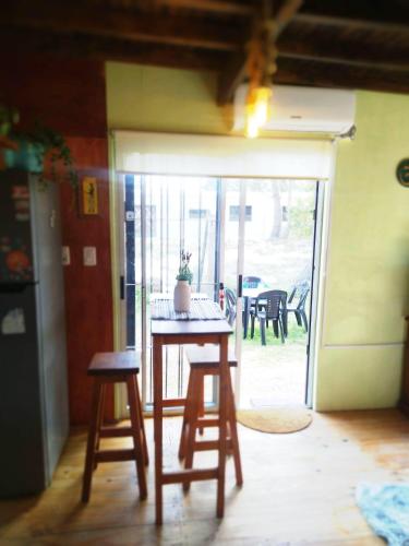 a table and two stools in a room with a patio at Hermosa Cabaña romantica, bosque, lago y mar in El Pinar