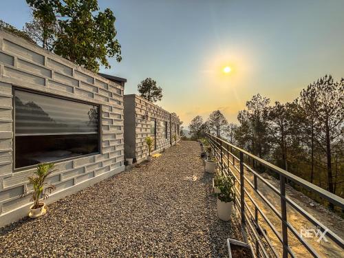 a building with a balcony with plants on it at Anupraas Resort in Lansdowne