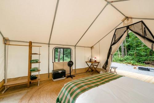 a room with a bed in a tent at Classic Safari Tent in the Heart of the Adirondack Wilderness, near Lake George, New York in Corinth