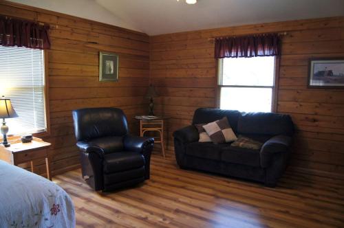 a living room with a couch and a chair at Secluded Cabin Ideal for a Romantic Getaway in the Umpqua River Valley of Oregon in Elkton