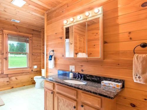 ein Badezimmer mit einem Waschbecken und einer Holzwand in der Unterkunft Gorgeous and Spacious Cabin Rental for a Group Vacation near Hocking Hills State Park, Ohio in Cedar Grove