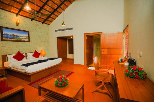 a bedroom with a bed and a living room at Vaidekam Resorts & Wellness, Kannur in Kannur