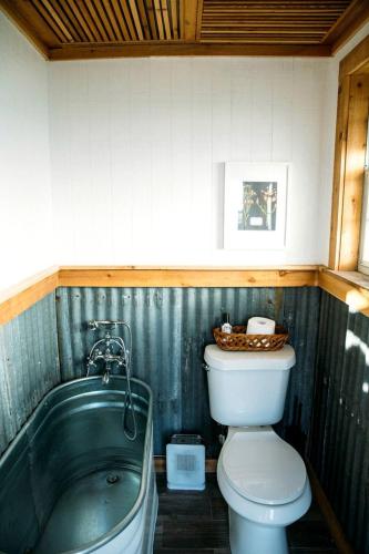 a bathroom with a toilet and a bath tub at Rustic Tiny House Rental for Weekend Getaways from Dallas in Wilmer