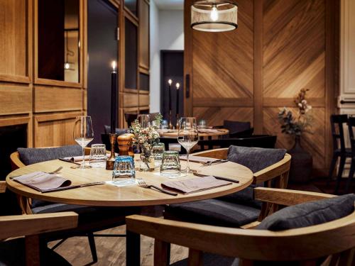 a dining room with tables and chairs with wine glasses at Hotel Mondial am Dom Cologne MGallery in Cologne