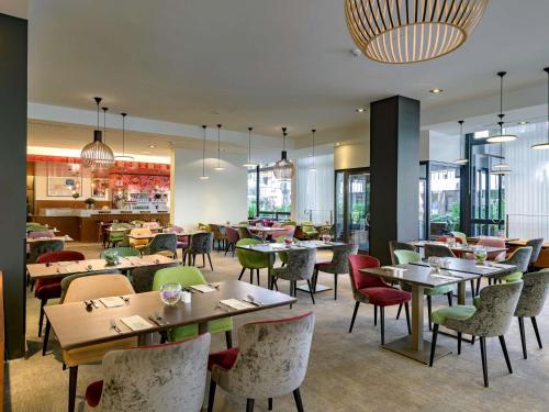 a restaurant with tables and chairs and a bar at Hotel Mondial am Dom Cologne MGallery in Cologne