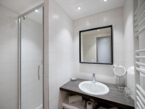 a white bathroom with a sink and a mirror at 2-room holiday flat with sea view in Residence du Bailli, Rayol-Canadel-sur-Mer in Rayol-Canadel-sur-Mer