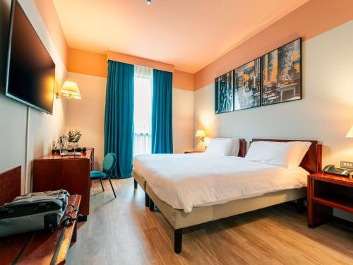 a hotel room with a bed and a television at Mercure Bologna Centro in Bologna