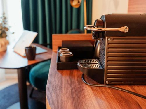 a toaster sitting on top of a wooden table at Mercure Bologna Centro in Bologna