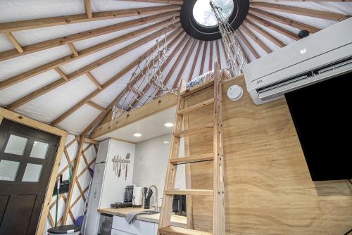 a ceiling with a clock and a ladder in a kitchen at Secluded Off-Grid Yurt with Forest Views Near Trails in Sears, Michigan in Sears