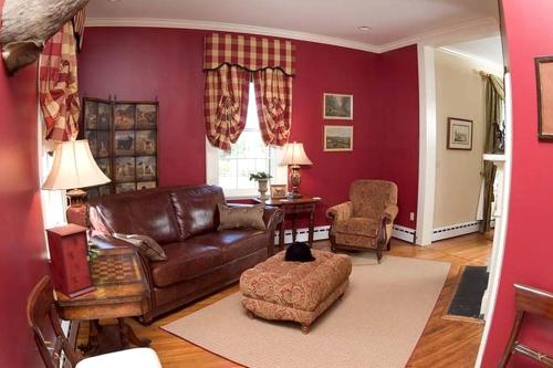 a living room with a brown leather couch and chair at 1856 Manor Vacation Rental on Huge Horse and Cattle Farm near Charlottesville, Virginia in Gordonsville