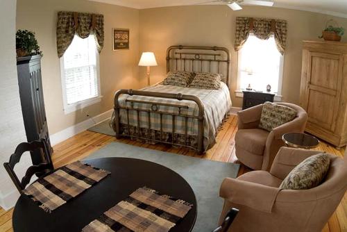 a bedroom with a bed and a table and chairs at 1856 Manor Vacation Rental on Huge Horse and Cattle Farm near Charlottesville, Virginia in Gordonsville