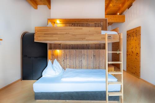 a bunk bed with a ladder in a room at Försterhaus & Haus Andrea in Mayrhofen