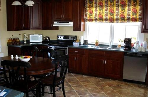 a kitchen with wooden cabinets and a table with a tableablish at 1856 Manor Vacation Rental on Huge Horse and Cattle Farm near Charlottesville, Virginia in Gordonsville
