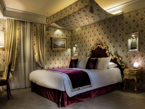 a bedroom with a large bed with floral wallpaper at Papadopoli Hotel Venezia - MGallery Collection in Venice