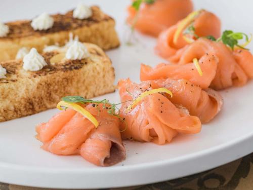 a plate of food with shrimp and bread at Papadopoli Hotel Venezia - MGallery Collection in Venice