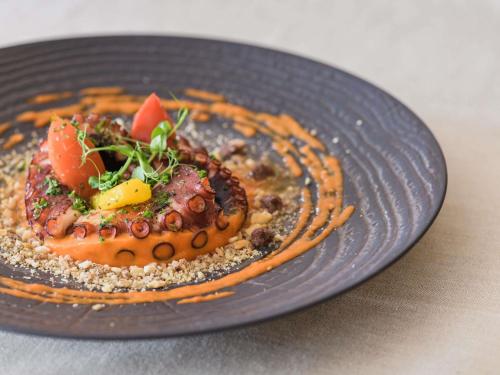a blue plate of food on a table at Papadopoli Hotel Venezia - MGallery Collection in Venice