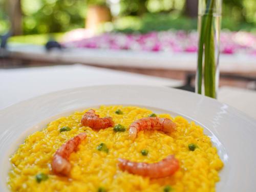 a white plate of food with shrimp on it at Papadopoli Hotel Venezia - MGallery Collection in Venice