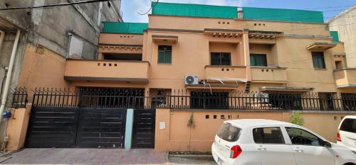 a white car parked in front of a building at Pixa Guest House in Dargai