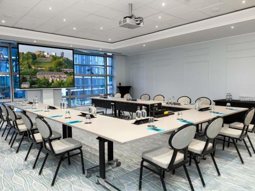 a conference room with tables and chairs and a projection screen at Sofitel Luxembourg Europe in Luxembourg