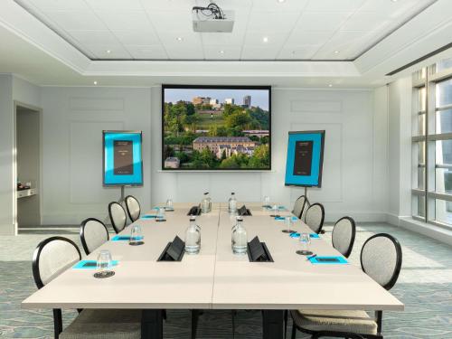 a conference room with a large white table and chairs at Sofitel Luxembourg Europe in Luxembourg
