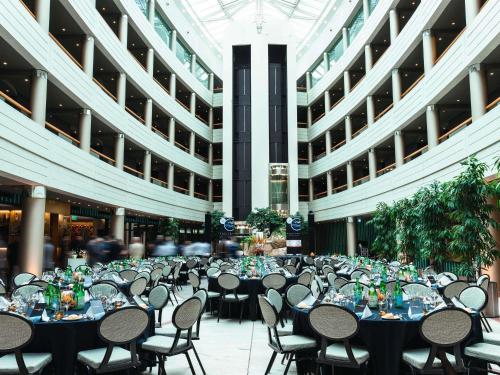 a long row of tables and chairs in a building at Sofitel Luxembourg Europe in Luxembourg