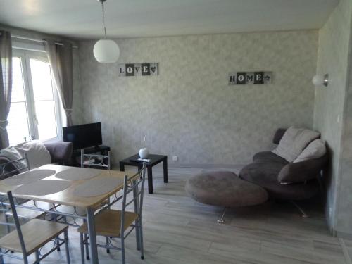 a living room with a couch and a table at Les Petits Souliers in Lestrem