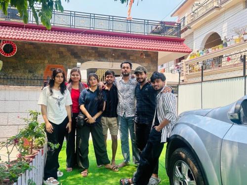 a group of people standing in front of a car at Nani s House - Warmth & Comfort in Dehradun