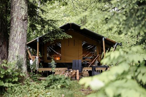 a cabin in the middle of a forest with trees at Outstanding Safari Tent with Fire Pit and Nice Sights in North Woodstock, New Hampshire in Woodstock
