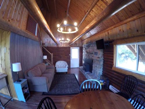 un soggiorno di una baita in legno con un divano e un camino di Traditional Log Cabin Rental near the Grand Tetons in Alpine, Wyoming ad Alpine