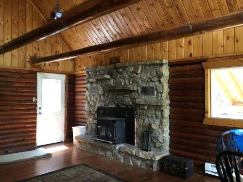 una stanza con un camino in pietra in una baita di Traditional Log Cabin Rental near the Grand Tetons in Alpine, Wyoming ad Alpine