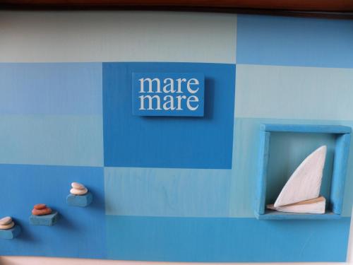 a blue wall with a model of a paper boat at Mare Mare Suites in Mali Lošinj