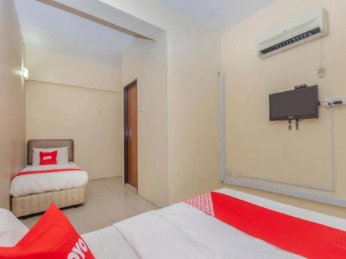 a bedroom with two beds and a tv on the wall at OYO 89703 B Link Hotel in Johor Bahru