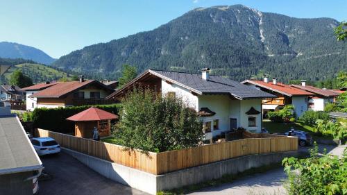a house with a fence in front of a mountain at Haus Gaichtspitzblick in Weissenbach am Lech