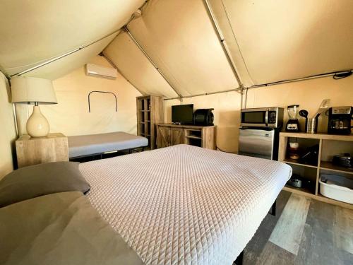 a bedroom with a bed in a small room at Charming Safari Tent on the San Marcos River near Kingsbury, Texas - Perfect for an Aquatic Adventure in Staples