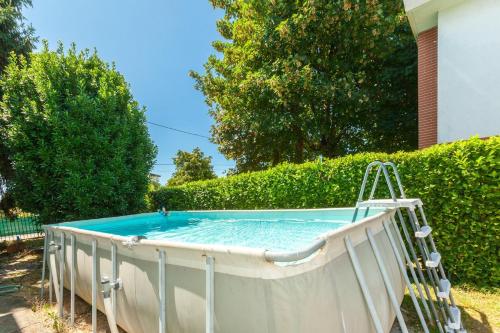una piscina en un patio junto a un seto en Dai Gheller Villa luminosa con piscina vicino Como e Milano, en Carbonate