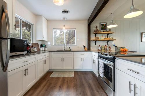a large kitchen with white cabinets and a sink at Spacious Chic Cabin with Private Yard in Marble Falls, Texas in Smithwick