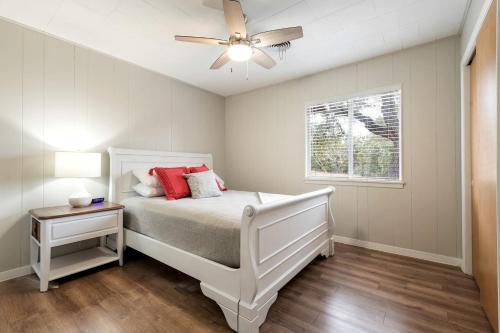 a bedroom with a white bed and a ceiling fan at Spacious Chic Cabin with Private Yard in Marble Falls, Texas in Smithwick