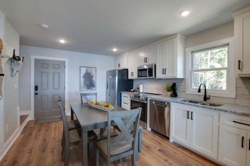 a kitchen with white cabinets and a table with chairs at Gorgeous Cabin Great for Groups or Families with Jacuzzi, Fire Pit and Views in Alabama in Grant