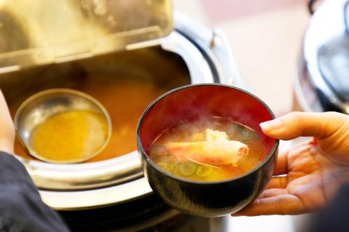 a person holding a cup of soup in front of a microwave at Sennentei in Yurihama