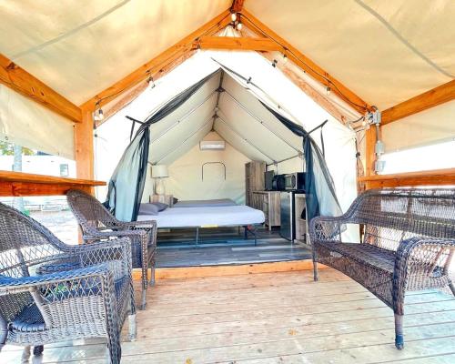 a bedroom in a tent with chairs and a bed at Gorgeous Glamping Site on the San Marcos River: Family-Friendly Safari Tent near Kingsbury, Texas in Staples